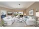 Spacious living room with white sofas, glass coffee table, and sliding doors to the outdoor area at 4906 Turtle Creek Trl, Oldsmar, FL 34677