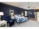 Comfortable main bedroom features attractive blue accent wall, fan, and bright light at 4906 Turtle Creek Trl, Oldsmar, FL 34677
