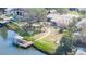 Waterfront property featuring a private dock, lush landscaping, and screened-in porch overlooking the tranquil canal at 4907 W Spring Lake Dr, Tampa, FL 33629