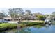 Scenic view of waterfront property featuring boat dock, and lush landscaping at 4907 W Spring Lake Dr, Tampa, FL 33629