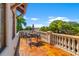 Outdoor balcony featuring terracotta tile, a dining set, and views of lush greenery at 4911 W Melrose S Ave, Tampa, FL 33629