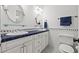 Bathroom featuring dual sinks, white cabinets, black and white floor tile and blue accents at 4911 W Melrose S Ave, Tampa, FL 33629