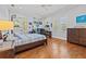 Bedroom with wooden floors, ceiling fan and large windows, decorated with fun decor and personal items at 4911 W Melrose S Ave, Tampa, FL 33629