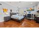 Well-lit bedroom with wood floors, fan, desk, bed, and French doors to a balcony at 4911 W Melrose S Ave, Tampa, FL 33629
