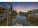View from the dock showing a boat lift, canal, and waterfront neighborhood with beautiful sunrise at 4911 W Melrose S Ave, Tampa, FL 33629