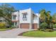 Beautiful two-story home with a well-manicured lawn and a brick driveway leading up to the two car garage at 4911 W Melrose S Ave, Tampa, FL 33629