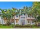 Stunning home featuring a white stucco exterior, red tile roof accents and lush tropical landscaping at 4911 W Melrose S Ave, Tampa, FL 33629