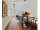 Elegant hallway with wood floors, iron railing, and natural light from large windows at 4911 W Melrose S Ave, Tampa, FL 33629