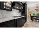 Gourmet kitchen featuring black cabinetry, marble countertops, and a gas cooktop with stainless steel hood at 4911 W Melrose S Ave, Tampa, FL 33629
