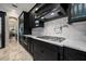 Elegant kitchen featuring black cabinetry, marble backsplash, and stainless steel appliances at 4911 W Melrose S Ave, Tampa, FL 33629