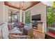 Inviting covered patio with fireplace, TV, comfortable seating, and beautiful views of the pool at 4911 W Melrose S Ave, Tampa, FL 33629