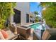Private backyard oasis featuring a sparkling pool, fire pit, outdoor seating area, and lush tropical landscaping at 4911 W Melrose S Ave, Tampa, FL 33629