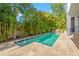 Inviting backyard swimming pool surrounded by palm trees and stone patio at 4911 W Melrose S Ave, Tampa, FL 33629