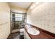 Bathroom featuring tiled shower with glass door, vanity with sink, and palm wallpaper at 5105 W Cleveland St, Tampa, FL 33609