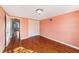 Empty bedroom with hardwood floors, closet, and hallway access at 5105 W Cleveland St, Tampa, FL 33609