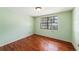 Bright bedroom with hardwood floors, light-green walls, and natural light from a large window at 5105 W Cleveland St, Tampa, FL 33609