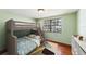 Cozy bedroom with a bunk bed, light-green walls, and natural light from a window at 5105 W Cleveland St, Tampa, FL 33609