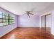 Empty bedroom with ceiling fan, large window, and mirrored closet at 5105 W Cleveland St, Tampa, FL 33609