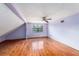 This bedroom features a ceiling fan, hardwood floors, and natural light from a window at 5105 W Cleveland St, Tampa, FL 33609