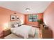 Staged bedroom with bed, side tables, artwork, and large window for natural light at 5105 W Cleveland St, Tampa, FL 33609