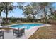 Backyard with in-ground swimming pool, patio area, and mature trees at 5105 W Cleveland St, Tampa, FL 33609