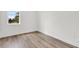 Simple bedroom with a window, light-colored walls, and hardwood floors at 5530 N 9Th St # 7, Tampa, FL 33604