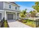 Beautiful townhome featuring tropical landscaping, neutral paint, and a grey paver driveway at 5530 N 9Th St # 7, Tampa, FL 33604