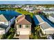 Aerial view of a house with a tile roof in a community with a lake and manicured lawns at 5850 Silverside Pine Ct, Bradenton, FL 34211