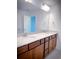 Bathroom featuring dual sinks, a large mirror, and wood cabinetry at 5850 Silverside Pine Ct, Bradenton, FL 34211
