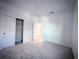 A bright bedroom features plush carpet, a closet with sliding doors, and neutral color palette at 5850 Silverside Pine Ct, Bradenton, FL 34211