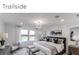 Spacious bedroom with large windows overlooking a lake and a decorative chandelier at 5850 Silverside Pine Ct, Bradenton, FL 34211