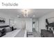 Bright bedroom with a statement chandelier, gray upholstered headboard, and neutral color palette at 5850 Silverside Pine Ct, Bradenton, FL 34211