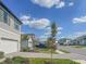Street view of the property showcasing its well-kept lawn, gray exterior, and paver driveway at 5850 Silverside Pine Ct, Bradenton, FL 34211