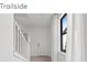 Bright hallway with white walls, staircase, modern round mirror, and natural light at 5850 Silverside Pine Ct, Bradenton, FL 34211