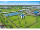 Aerial view of a community playground, basketball court and fenced in lawn area with mature shade trees at 5850 Silverside Pine Ct, Bradenton, FL 34211