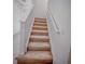 Carpeted staircase with white railing leads to the upper level of the home at 5850 Silverside Pine Ct, Bradenton, FL 34211