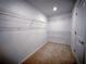 Unfinished walk-in closet with carpet flooring and metal shelving for efficient storage at 5850 Silverside Pine Ct, Bradenton, FL 34211
