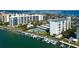 Aerial view of a waterfront condo community featuring a pool, tennis court, boat docks and tiki bar at 660 Island Way # 202, Clearwater Beach, FL 33767