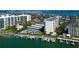 Aerial view of a waterfront condo community featuring a pool, tennis court, boat docks and tiki bar at 660 Island Way # 202, Clearwater Beach, FL 33767