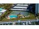Aerial view of a waterfront condo community featuring a pool, tennis court, boat docks and tiki bar at 660 Island Way # 202, Clearwater Beach, FL 33767