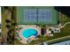 Aerial view of a waterfront condo community featuring a pool, tennis court, boat docks and tiki bar at 660 Island Way # 202, Clearwater Beach, FL 33767