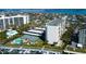 Aerial view of a waterfront condo community featuring a pool, tennis court, boat docks and tiki bar at 660 Island Way # 202, Clearwater Beach, FL 33767