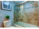 Bathroom with a tiled tub and shower, toilet, and framed artwork on the wall at 660 Island Way # 202, Clearwater Beach, FL 33767