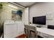 Laundry room featuring a white washer and dryer, shelving, and a desk area for added functionality at 660 Island Way # 202, Clearwater Beach, FL 33767