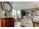 Bright living room features a large mirror, hardwood floors, and comfortable white furniture at 660 Island Way # 202, Clearwater Beach, FL 33767
