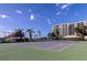 Community tennis court with palm trees and a covered seating area in the background at 660 Island Way # 202, Clearwater Beach, FL 33767