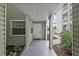 Inviting entrance with sage green siding, decorative columns, and a neutral-colored walkway at 6916 Stones Throw N Cir # 9110, St Petersburg, FL 33710