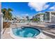 Community features pool, spa, lounge chairs and tables with blue umbrellas at 6916 Stones Throw N Cir # 9110, St Petersburg, FL 33710