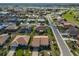 An aerial view of a tan roofed home in a community with lake views and a golf course at 701 Baltusrol Way, Sun City Center, FL 33573