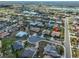 An aerial view of a tan roofed home in a community with lake views at 701 Baltusrol Way, Sun City Center, FL 33573